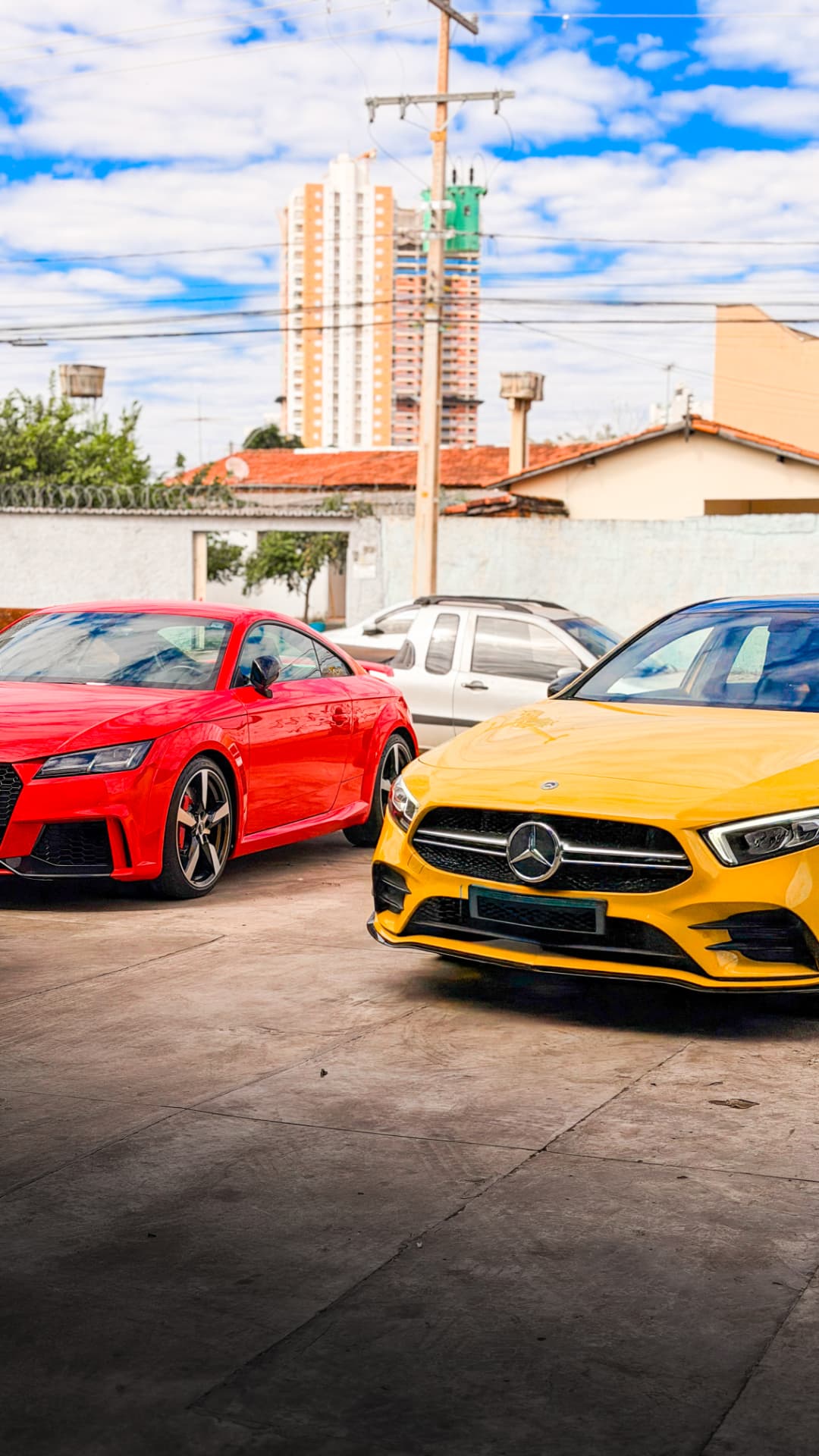 Audi TT RS vermelho e Mercedes-AMG A35 amarelo no pátio da oficina