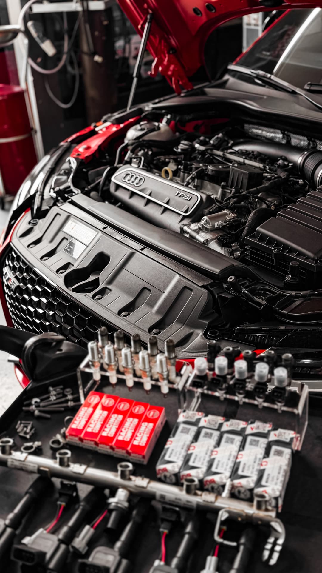 Motor Audi TFSI aberto com velas e bicos preparados para manutenção