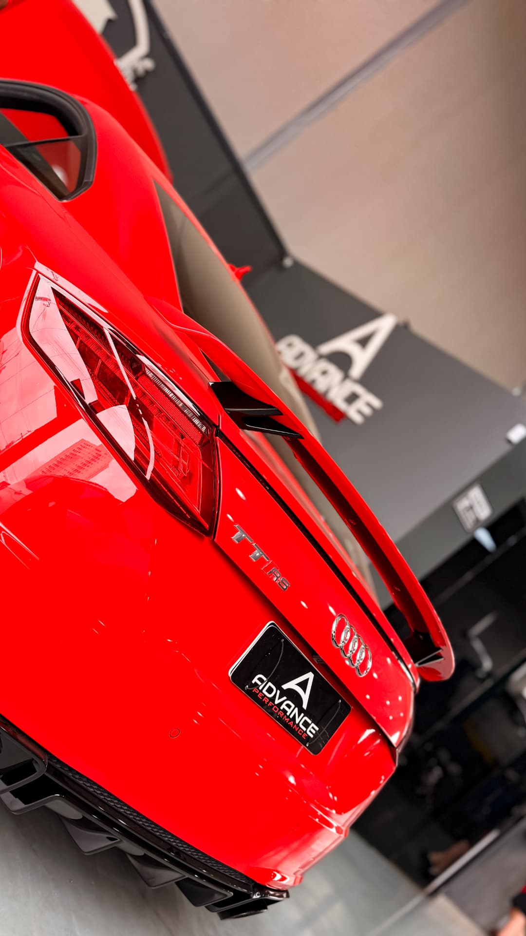 Audi TT RS vermelho com placa Advance Performance na oficina